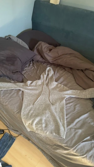 Ljusgrå hoodie med dragsko - Säljer en stilren ljusgrå kashmir hoodie med huva och dragsko. Hoodien har en klassisk passform och är tillverkad i mjukt material, perfekt för en avslappnad look. Inga synliga loggor eller tryck, enkel och clean design som passar till det mesta. Passar S och Xs