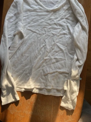 Vit stickad tröja från J.Lindeberg - Säljer en stilren vit stickad tröja från J.Lindeberg. Tröjan har lång ärm, rund halsringning och är tillverkad i ett mjukt, tunt stickat material. Perfekt för lager på lager och enkel att matcha med olika outfits.