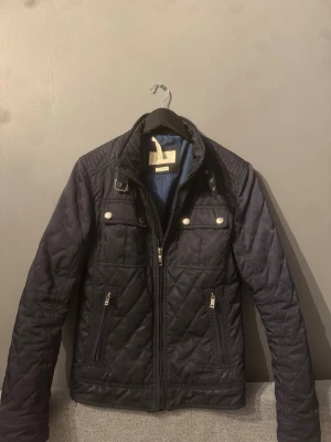 Svart quiltad jacka från Zara Man - Snygg matinblå quiltad jacka från Zara Man. Det är storlek M men passar XS-S. Skicket är bra men finns några små saker som tyder på användning men det är något som inte märks. Kontakta gärna vid intresse:)