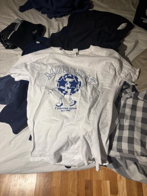 Vit Moderat t-shirt med tryck - Säljer denna T-shirt med tryck som är moderaterna och är perfekt till sommaren. T-shirten är helt ny så inga defekter eller liknande. Den är i storlek S men skulle gissa på att den passar xs. Om de skulle vara något du undrar, så är de bara att skriva till mig🙌🏻