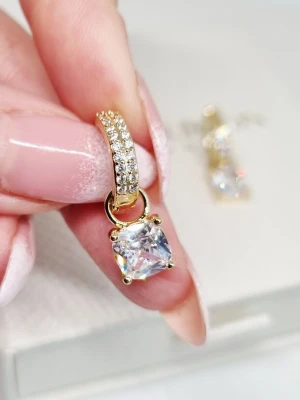 Guldpläterade örhängen med kristaller - Snygga örhängen från Cubic Button i guldpläterad metall med gnistrande vita kristaller. Hängande fyrkantig sten och små infattade stenar på bågen ger en lyxig känsla. Perfekt accessoar för att lyfta din stil. Lådan ingår ej.