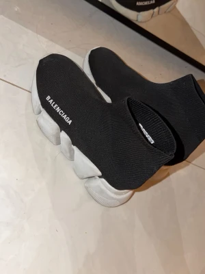 Balenciaga Speed Trainer svarta sneakers - Svarta Balenciaga Speed Trainer sneakers med vit chunky sula och stickad ovandel i textil. Loggan står tryckt i vitt på sidan. Skorna har en strumpliknande passform och modern, sportig look.