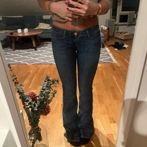 Mörkblå bootcut jeans - Säljer ett par mörkblå bootcut jeans med klassisk femficksdesign och låg midja. midja:37 innerbenslängd:84