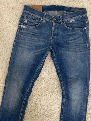 DONDUP GEORGE JEANS - Säljer dessa Dondup jeans i storlek W31, använda fåtal gånger och i mycket fint skick (9/10), nypris 4000 kr säljs för 899 kr, hör av dig vid frågor eller om du vill ha fler bilder 🙌 Slitningar gjorda i fabrik!! 
