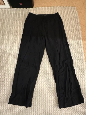 Svarta linnebyxor - Säljer ett par svarta linnebyxor med raka ben. Byxorna har resår i midjan baktill och är tillverkade i ett lätt och luftigt linnematerial.