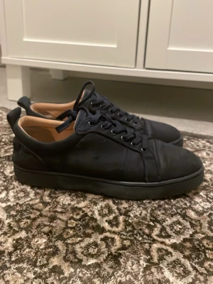 Svarta loubs i läder - Snygga svarta loubs med slät ovandel och klassisk snörning. Skorna har en låg profil och diskret design med svart yttermaterial och ljusbrunt innerfoder. Perfekta för dig som gillar stilrena och minimalistiska skor.