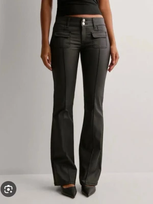 Svarta bootcut skinnbyxor från Nelly - Snygga svarta jeans med bootcut passform. Jeansen har klassisk femficksdesign, knapp och dragkedja framtill. Perfekta för dig som gillar en stilren och trendig look. Uppsyda några cm 