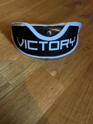 Innebandyglasögon Unihoc & Victory hakskydd - Säljer ett par innebandyglasögon från Unihoc med vit och grön båge samt genomskinliga linser. Medföljer även ett svart och vitt hakskydd från Victory, perfekt för innebandyträning och match.