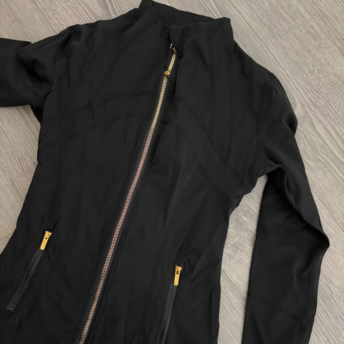 Svart vindjacka med gulddragkedjor