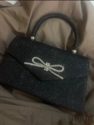 Glittrig svart kuvertväska med pärldetalj - Jätte snygg väska men lite smutsig inne i väskan 