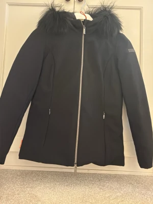 Svart parkasjacka med fuskpäls från RRD  - Svart jacka från RRD med dragkedja framtill och huva med svart päls. SOM NY!!  Endast använd en gång!! 