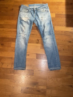 Dondup jeans - Säljer ett par ljusblå Dondups med slitningar på framsidan. Jeansen är i George modellen och är 90 cm långa 40 cm bredda. Pris ej hugget 