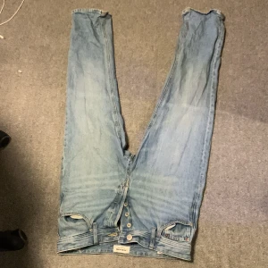 Ljusblå raka jeans från Weekday - Säljer ett par ljusblå jeans från Weekday med relaxed passform och klassisk femficksdesign. Jeansen har knäppning framtill och en patch bak i midjan. Perfekta för en avslappnad och trendig look.