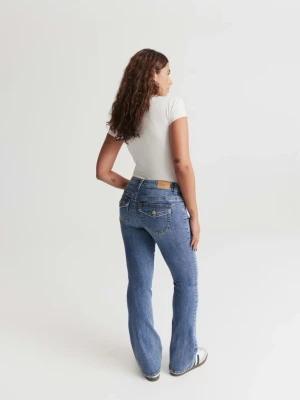 Blå bootcut jeans med fickdetaljer - Snygga blå bootcut jeans med klassiska fickor bak och fram, samt synliga sömmar. Jeansen har en normal passform och är tillverkade i bomull med en liten stretchkänsla. Perfekta för en avslappnad och trendig look.