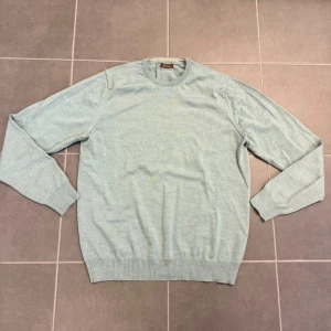 Ljusblå rundhalsad tröja Stenströms - Ljusblå tunn stickad tröja från Stenströms med rund halsringning och ribbade muddar vid ärmslut och nederkant. Perfekt för lager-på-lager och enkel att matcha med olika outfits. 