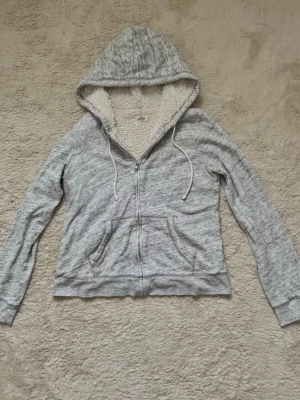 Grå zip up Hoodie Hollister  - Grå zip up Hoodie ifrån Hollister med vitt foder! 