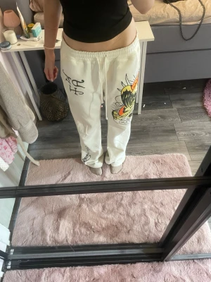 Vita mjukisbyxor med tryck - Vita mjukisbyxor med coola tryck. Perfekta för en avslappnad och häftig look. Sitter stort på dig då de är herr byxor, säljer billigt då de är fläckar ner till, men går att få bort de mesta i tvätten med fläckborttagning spray💗