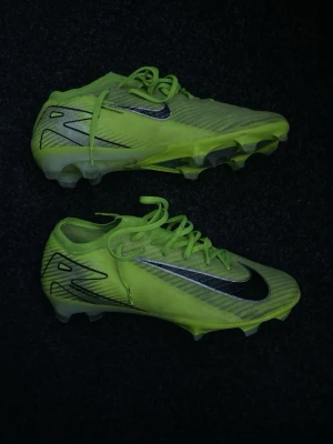 Nike Mercurial Gröna Elite(FG) - Säljer ett par Nike Mercurial fotbollsskor i neon-grönt med svarta detaljer och logga. Skorna har snörning och mönstrad ovandel för extra grepp. Perfekta för dig som vill sticka ut på planen och få bra bollkontroll. Inte använt så mycket eftersom att jag har ett annat par. Elite modellen.