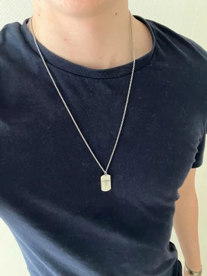 Silverfärgat halsband bricka - Tjena👋 Säljer detta stilrena halsband i silverfärg med en rektangulär bricka som hänge🤩 Kedjan är tunn och har ett klassiskt karbinlås😮‍💨 Perfekt accessoar för en enkel men snygg look🧼 61 cm lång📐Meddela gärna vid frågor📩