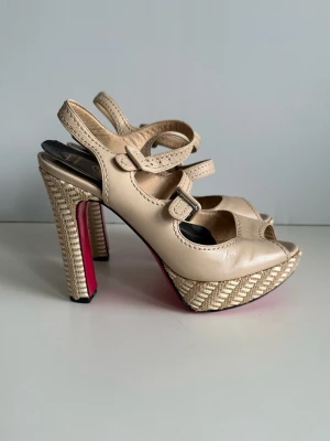 Beige platåsandaler från Luciano Padovan- storlek 36,5 - Snygga beige sandaler / sandaletter med platå och höga flätade klackar från erkände italienske skodesignern Luciano Padovan. Storlek 36,5. Skorna har två remmar med spännen i 100% äkta läder och mjukt avrundad öppen tå. Härlig undersula i läder i lackad rosa kontrastfärg. Vackra kvalitativa italienska designerskor i läder med detaljer i flätad textil. Nypris 5500:-. Fint skick! 