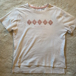 Vit Juicy Couture t-shirt med tryck - Vit t-shirt från Juicy Couture med rosa diamantformade tryck och logga på bröstet. Tröjan har rund hals och korta ärmar. Perfekt för dig som gillar clean och snygg streetstil🩷🩷