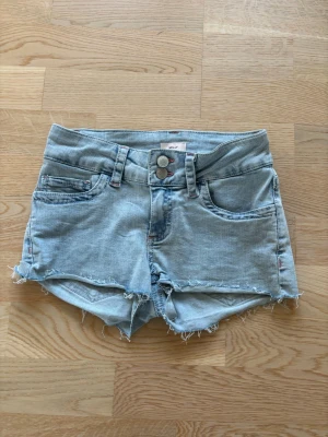 Ljusblå jeansshorts med råa kanter - Aldrig använda. Köpte för 499kr
