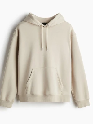 Beige hoodie med huva och magficka - Säljer en stilren beige hoodie från H&M med klassisk huva och dragsnören. Hoodien har en stor magficka framtill och ribbade muddar vid ärmslut och nederkant. Tillverkad i mjukt bomullsmaterial som är skönt att ha på sig.