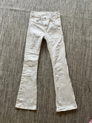 Vita bootcut jeans Coco cotton club - Säljer ett par vita bootcut jeans från Coco.  Jeansen har klassisk femficksmodell, normal midja och utsvängda ben. Materialet är mjukt och följsamt denim. Perfekta för dig som vill ha en clean och fräsch look. Mått w27/L 32