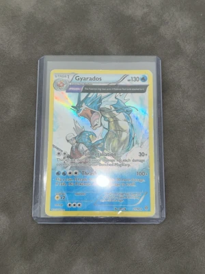 Pokémonkort Gyarados holo - Säljer ett holografiskt Gyarados Pokémonkort i plastficka. Kortet har en glansig yta med blå, silver och röda detaljer och är från Pokémon Trading Card Game. Perfekt för samlare eller dig som vill uppgradera din kortlek! Den är lite skadad så priset kan andräs om du vill 