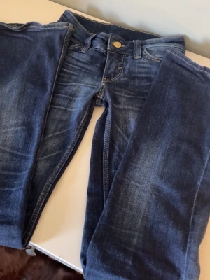Mörkblåa jeans från cheap Monday storlek w23 - Säljer ett par mörkblåa lågmidjade bootcut jeans från cheap Monday/ weekday. Modellen heter booty bei och är i färgen star blue. Storleken är w23 och längd 30 men funkar även till de som har 146-152/158. Midjemåtten rakt över är 30cm och från gylfen till längst ner är runt 20cm. Väldigt bra skick och bara använda några få gånger. Säljer eftersom de inte gått till användning💕