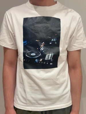 Vit ”NOT EVERYONE UNDERSTANDS HOUSE MUSIC” tröja från gardegrish - Vit t-shirt med tryck av en DJ-mixer på bröstet. Klassisk passform och rund halsringning. Perfekt för dig som gillar musik och vill ha en cool och stilren look. Hör av er gällande funderingar 