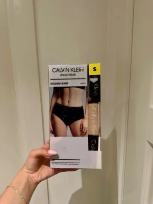 Calvin Klein Modern Brief 3-pack trosor - 3-pack Calvin Klein Modern Brief trosor i svart, beige och randiga. Trosorna har en sömlös design för extra komfort och är tillverkade i mjukt, stretchigt material med den klassiska logotypen på midjeresåren. 