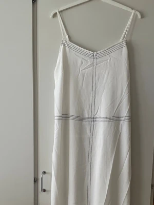 *NY*Vit/Svart maxiklänning i stl L fr SoVogue - Ny med lapp. Bara provad. Skönt svalt material, tunt fodrad, reglerbara axelband. Står stl L, sitter bra och lite loose på mig som är en 42/44. Går ner till mina fotknölar, jag är 1,67. Längd: Ca 139 cm, Byst: Ca 82 cm. Nypris: 299 sek, Pris nu: 120 sek 