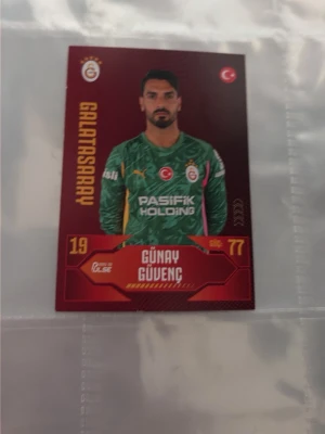 Galatasaray samlarkort fotboll 2-pack - Två samlarkort med fotbollstema från Galatasaray. Ena kortet har grön bakgrund och visar målvakt i grön tröja, det andra har gul och röd bakgrund med spelare i matchtröja. Perfekt för dig som gillar fotboll och samlar på sportkort.