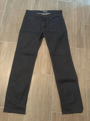 Dressman jeans - Snygga mörkgrå jeans med rak passform och klassisk femficksdesign. Jeansen har en stilren look utan slitningar eller dekorationer, perfekta för en clean och enkel stil. Materialet är mjukt och följsamt denim. Byxorna är köpta på dressman och är modellen Nevada strl 34/32 Straight. Kontakta mig vid frågor! Priset går att diskutera
