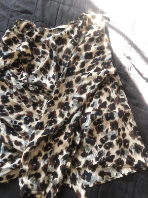 Leopardmönstrad omlottblus - Snygg leopardmönstrad omlottblus i tunnt, lätt material. Blusen har långa ärmar och knytdetalj i midjan. Från only storlek 36 