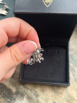 Maria Nilsdotter Halsband - Superfint halsband från Maria Nilsdotter i silver med en röd sten, deras "mini treasured teddy necklace" från en äldre kollektion. ❤️Superfint skick då den är väldigt sparsamt använt! Nyputsad, men skulle kanske behöva putsas lite noggrannare vid små utrymmen, tex öronen. Nypris är 2'295kr. Jag har kvitto och en tillhörande grön liten MN box som tillkommer. Halsbandet och berlocken är märkt med "Dotter" och "925"🪽Möts endast upp, antingen i Stockholm eller Uppsala😊pris kan diskuteras