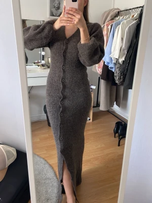 Brun stickad långklänning med knappar - Jättefin stickad långklänning från Gina tricot. Storlek XS, jag är 160cm lång 💕Denna är använd  1 gång så väldigt fint skick på den! 🥰