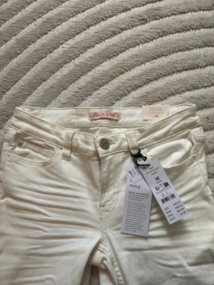 Vita flare jeans från Gina Tricot - Snygga vita jeans från Gina Tricot i modellen Slow Long Flare. Jeansen har hög midja, klassiska fem fickor och utsvängda ben. Tillverkade i bomull med lite stretch för skön passform. Perfekta för en trendig och fräsch look.💕😍