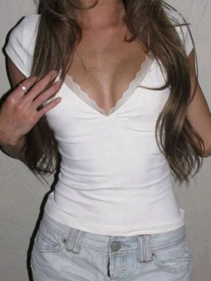 Vit v-ringad topp med spetskant - Snygg vit topp med djup v-ringning och spetskant längs urringningen. Modellen är tight och har korta ärmar. Perfekt att styla med jeans eller kjol för en trendig look.(ej mina bilder, shein bilder) 
