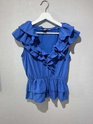 Blå volangtopp från H&M - Trendig blå topp från hm. Storlek 36, bra skick. 