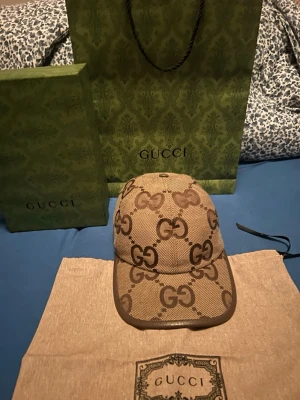 Gucci beige GG-monogram keps - Snygg beige keps från Gucci med klassiskt GG-monogram i brunt över hela kepsen. Justerbar rem bak och böjd skärm. Tillverkad i Italien  med detaljer i brunt läder. 