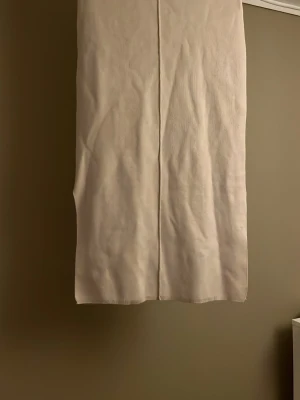 Beige rak långkjol i bomull - En stilren beige långkjol med rak passform. Kjolen är enkel och minimalistisk utan synliga detaljer eller mönster, vilket gör den lätt att matcha. Har två små fläckar på sig men jag är ganska säker på att dem kan gå bort i tvätten!