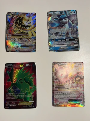 Pokémon holografiska samlarkort - Åtta unika Pokémon samlarkort med holografisk effekt: Mega Steelix, Glaceon, Tyranitar och Mega Audino. Korten är rektangulära och har färgstarka motiv med metallic-glans. Tillverkade av laminerad papp och passar perfekt för samlare och Pokémon-entusiaster. Plastfickor ingår också, VIKTIGT på kolla alla bilder eftersom den första ska det vara alla 8 men det fick inte plats 