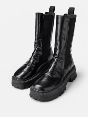 Svarta chunky läderstövlar - Snygga svarta stövlar i glansigt läder med högt skaft och grov sula. Stövlarna har resår på sidorna och dragflikar upptill för enkel påtagning. Perfekta för en trendig och edgy look.