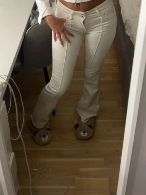 Vita utsvängda jeans med sömdetaljer - Snygga vita jeans med utsvängda ben och markerade sömmar framtill. Jeansen har låg midja är 163 sitter perfekt i längd jättebra skick säljer då de börjar bli för små!