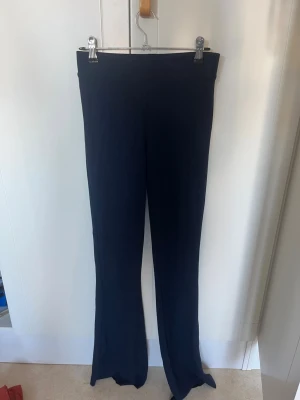 Mörkblå utsvängda leggings - Snygga mörkblå leggings med utsvängda ben och hög midja. De är stretchiga och sitter tajt upptill men släpper ut vid anklarna (bootcut) Om man vill ha fler bilder på plagget (på eller andra vinklar) är det bara att säga till så fixar jag det