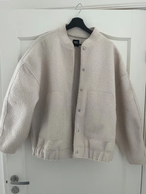 Beige oversized jacka från ZARA - Säljer en oversized beige jacka från ZARA med stora framfickor och tryckknappar. Storleken är M-L