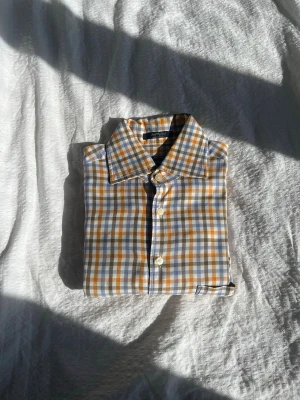 Rutig skjorta i blått och gult - Snygg rutig skjorta med klassisk krage i blått, gult och vitt.