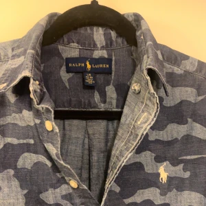 Ralph Lauren Camo Skjorta  - Riktigt fet camo skjorta som är riktigt svår att hitta nu för tiden. Skick 10/10. Storlek 14-16 men sitter som Xs-S. Jag är 180 och den sitter lite litet. Hör av er vid frågor eller funderingar 😂